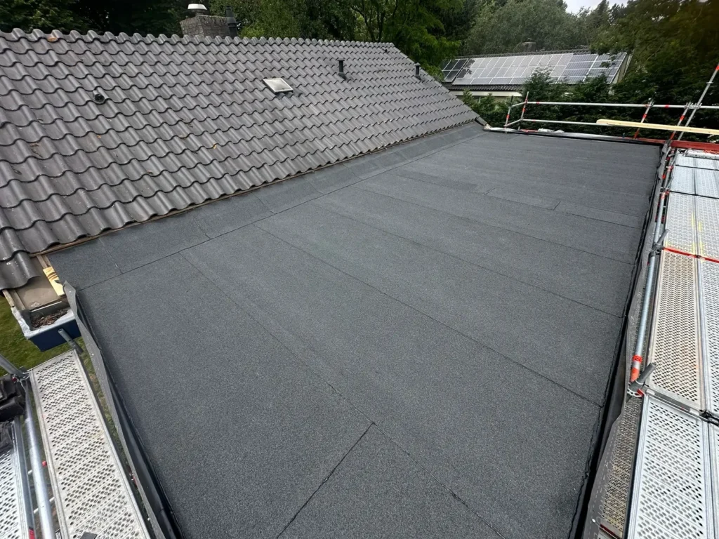 Opgeleverd bitumen dak op een dakopbouw met een steiger langs de dakrand in Akersloot