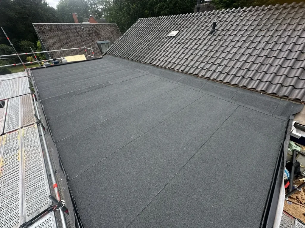 Nieuwe bitumen dakbedekking op een dakopbouw naast een pannendak in Assendelft