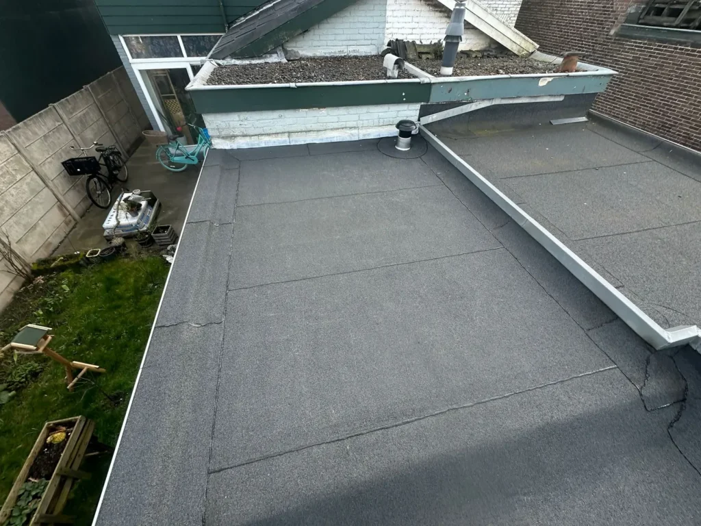 Nieuw bitumen dak met dakrandprofiel boven een achtertuin in Beverwijk
