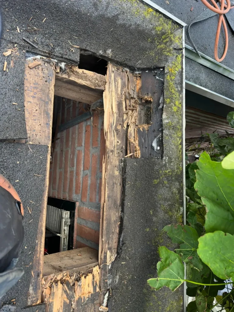 Gat in een plat dak waar verrot dakbeschot is weggehaald, met zicht naar binnen in Westzaan