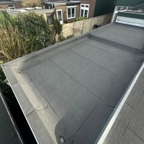 Plat dak van een aanbouw met nieuwe bitumen dakbedekking en aluminium daktrim in Bloemendaal