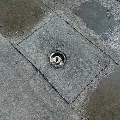 Nat plat dak met een dakafvoer in de bitumen dakbedekking in Castricum