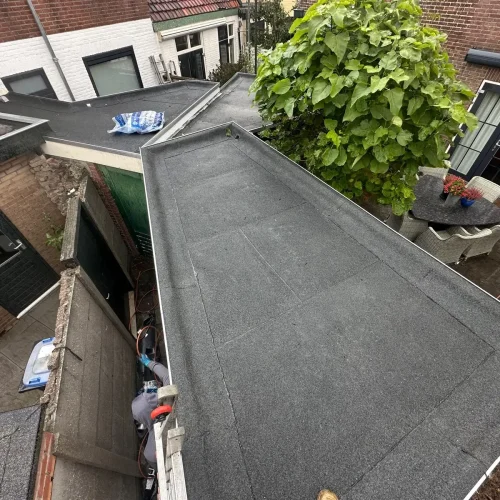 Nieuw bitumen dak van een schuur en aanbouw in een achtertuin in Heemskerk