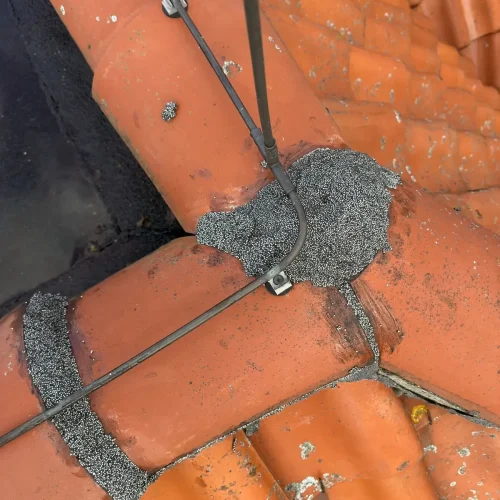 Nokvorsten opnieuw vastgezet met dakmortel op de kruising van de nok in Velsen