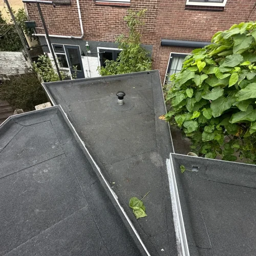 Platte daken van een aanbouw met nieuwe bitumen dakbedekking en een dakdoorvoer in Wijk Aan Zee